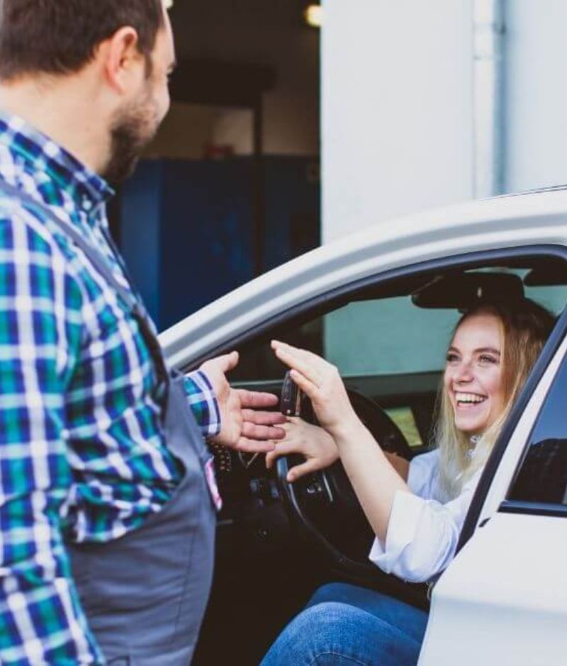 A man helping a customer out of the car at a westerville auto body shop